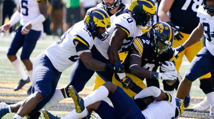 Iowa running back Kaleb Johnson is tackled by Michigan defenders.